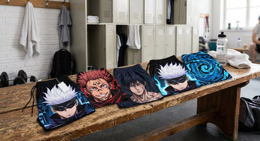 Pantaloncini Jujutsu Kaisen: cinque pantaloncini stampati con Gojo, Sukuna e Toji allineati su una panca dello spogliatoio