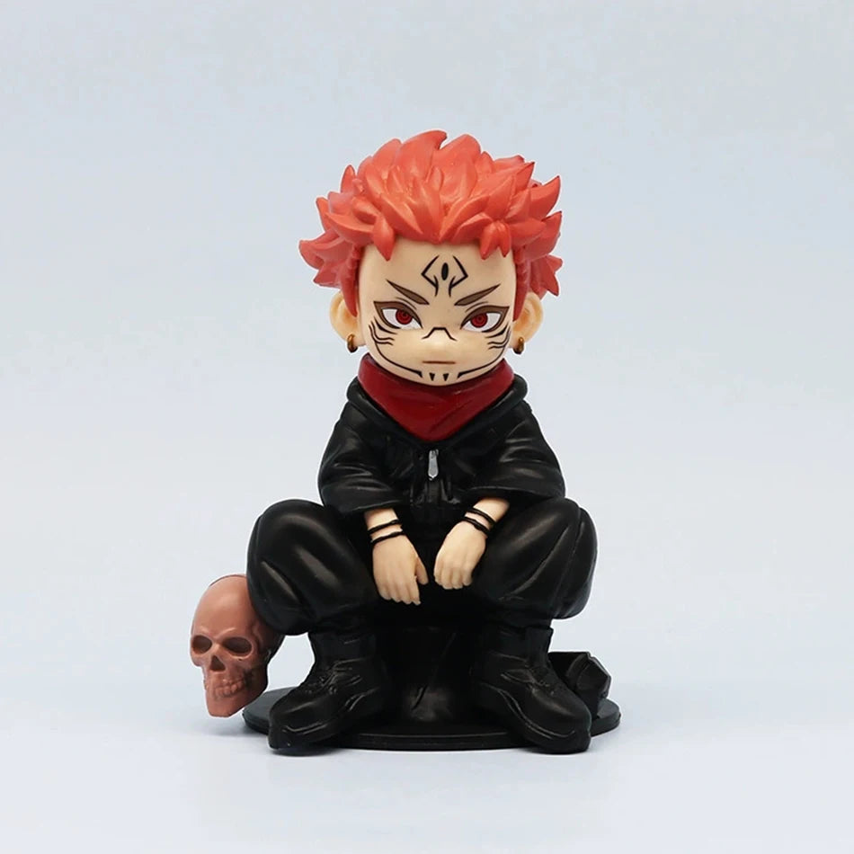 Figurine chibi accroupie en uniforme noir, col rouge, cheveux orange, crâne