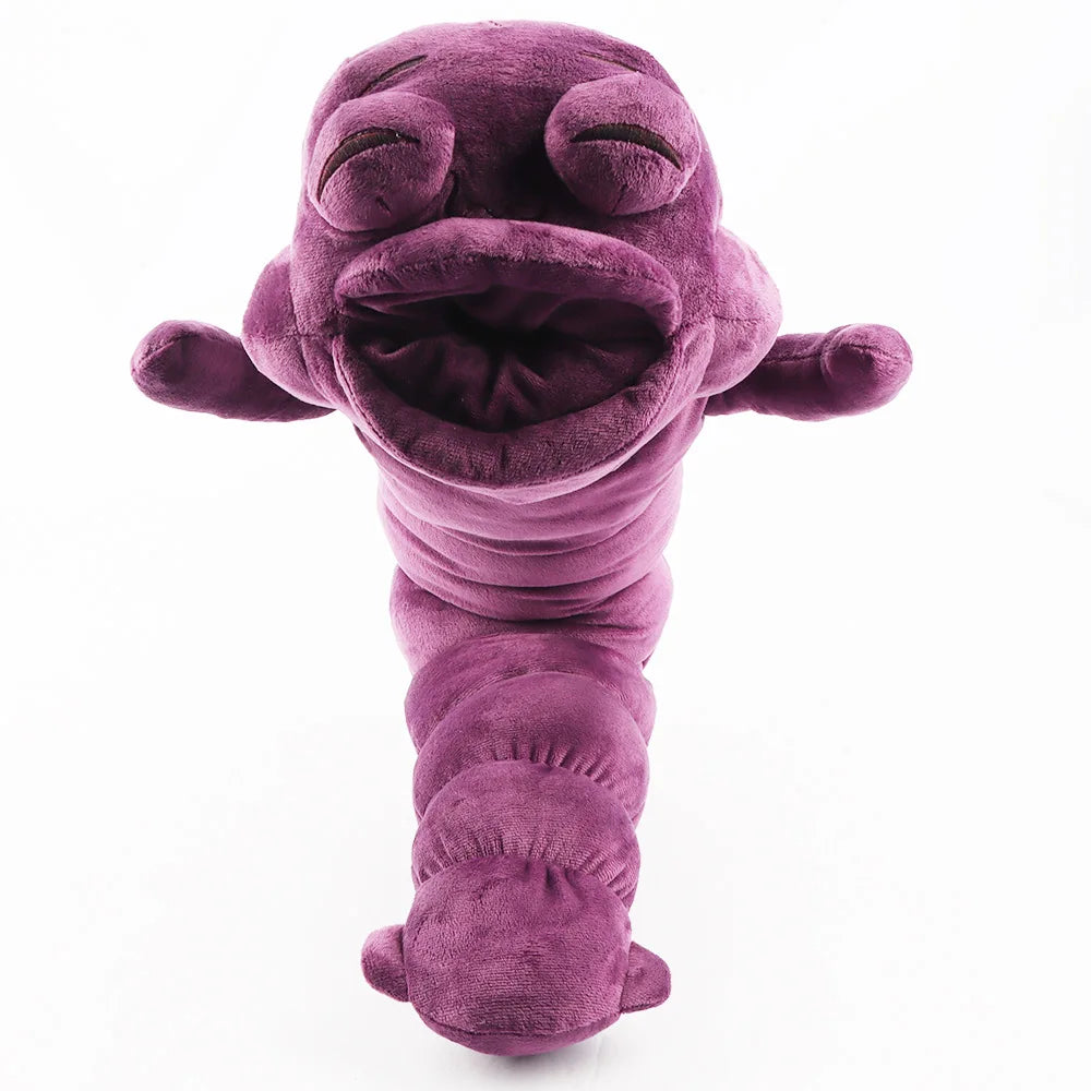 Peluche violette, tête repliée type mascotte, corps duveteux et petites pattes.