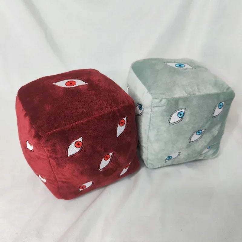 Lot de deux coussins cubes bleu clair et rouge, motifs d’yeux sur la housse.
